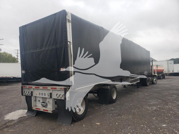 Mac Alum flatbed trailer with black curtains and tarp, rear view showing taillights and MAC trailer plate.