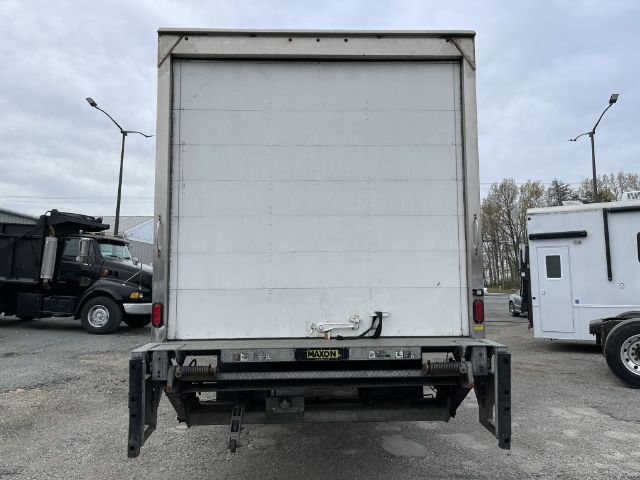 Box truck rear showing closed cargo area with hitch and bumper, rear lights, and metal bumper structure.