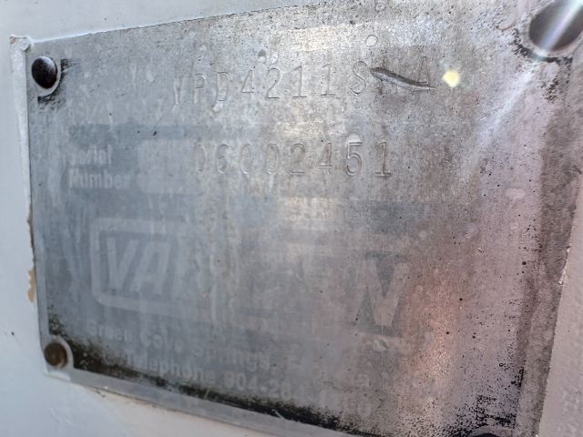 Metal identification plate on a used International vacuum truck showing stamped numbers and manufacturer logo.