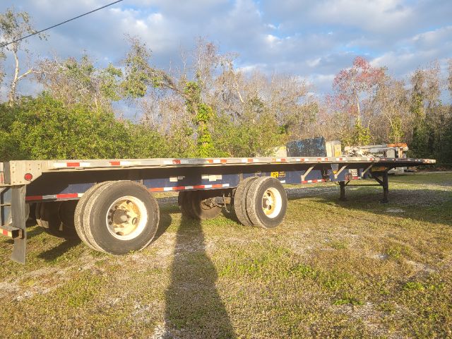 Great Dane 48X102 flatbed trailer showing dual rear axles and long steel deck with reflective tape.