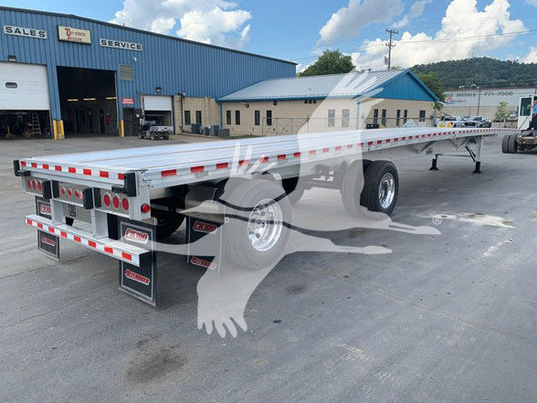 Flatbed trailer with sliding rear axle, silver aluminum deck, red and white reflective tape along edges, dual rear axles with mud flaps, lights, and country license plate area. The back shows brand badges and hydraulic components. 2026 Reit