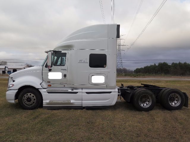 International Prostar truck cab and chassis side profile, white exterior, sleeper cab, dual rear axles, highway environment.