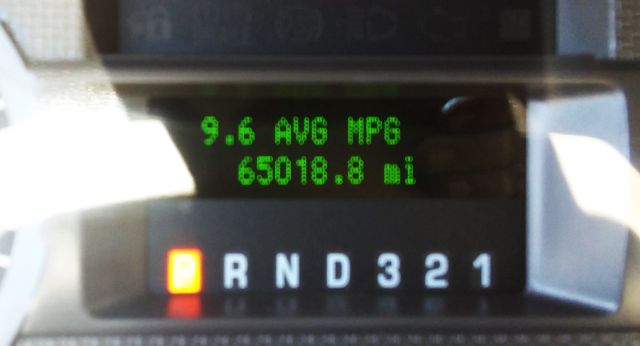 Dashboard display showing fuel economy 9.6 AVG MPG and 65018.8 mi, with gear shift indicator P R N D 3 2 1.