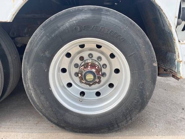 Wheel with tire showing DUNLOP branding and silver rim, hub with rusted center and lug nuts.