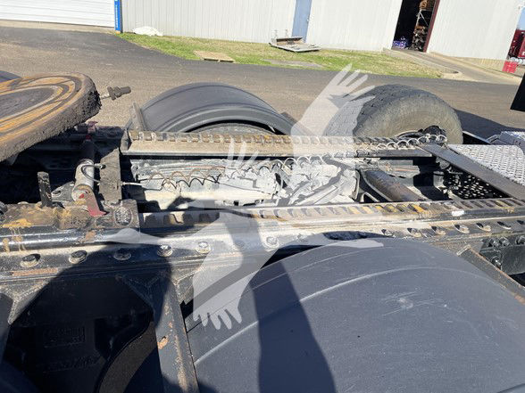 Kenworth truck chassis showing drivetrain and fifth wheel components.