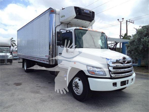 White freight truck with a large reefer box and a white front cab, loading area with a refrigeration unit on top of the cab. Visible text: none clearly legible on truck.