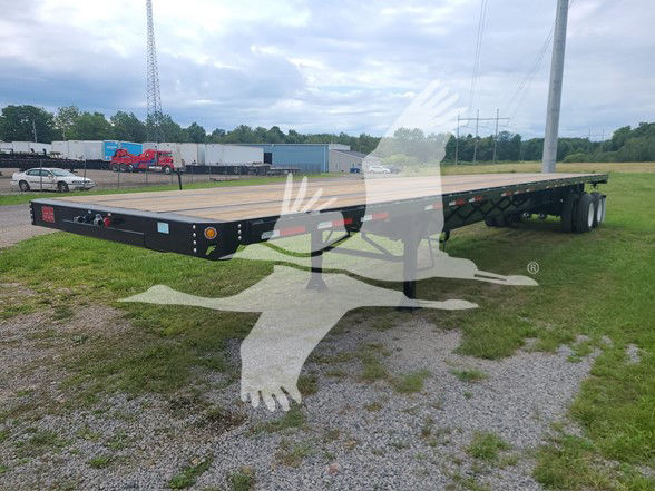 Fruehauf flatbed trailer in a yard showing long flatbed with tandem axles and ramps, with VIN and stock number visible in listing text.