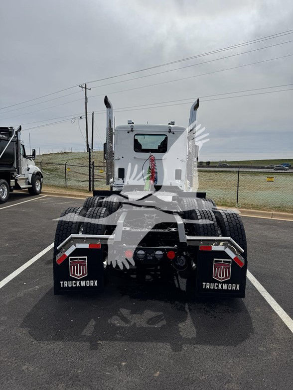 Kenworth T880 rear view showing dual rear axles, fifth wheel, mud flaps with TruckWorx logos, and white cab.