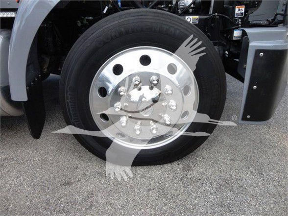 Peterbilt truck front wheel showing chrome wheel with multiple lug nuts, tire, and fender area.