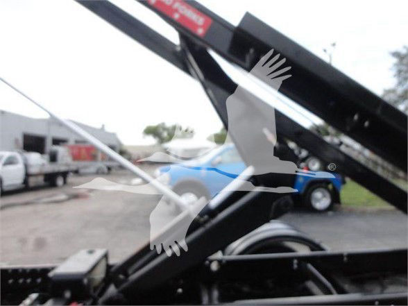 2023 Chevrolet Silverado 5500HD component image showing hydraulic arm and area with blurred trucks in background.