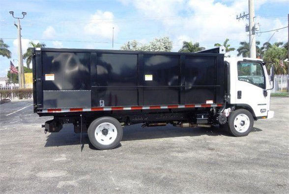 Isuzu NPR HD dump truck side view showing black dump body and white cab.