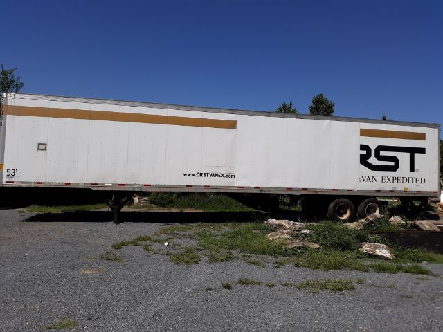 Trailer side view with 'RST' and 'VAN EXPEDITED' logo, white box trailer, tan stripes, 53' length, parked on gravel with grass and some debris.