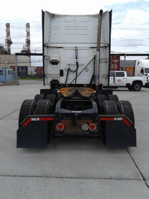 Rear view of a Volvo D13 truck tractor chassis with fifth wheel, mud flaps, and dual rear axles.