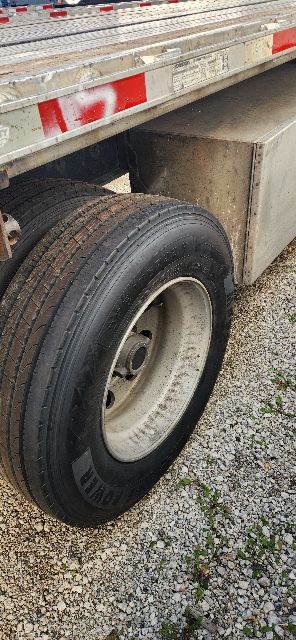Trailer wheel and fender area of a 2019 Utility Combo Flatbed trailer showing dual rear axle tire and metal ramp/side panel.