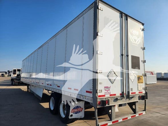 Trailer showing rear and side view of a 2018 Wabash van trailer with white graphics, dual rear doors, and dual rear axles.