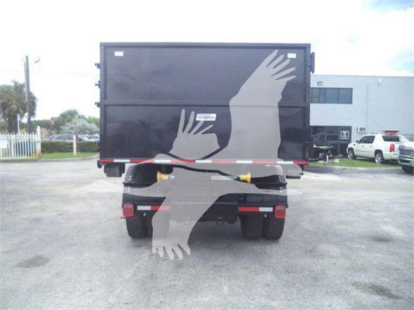 Rear view of a Freightliner BUSINESS CLASS M2 106 dump truck with a large gray graphic of birds on the tailgate.
