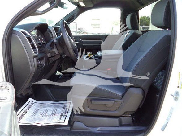 Truck interior front seats and dashboard of a 2023 Ram 4500 SLT, right-hand drive shows front seats, steering wheel, center console, and driver-side door