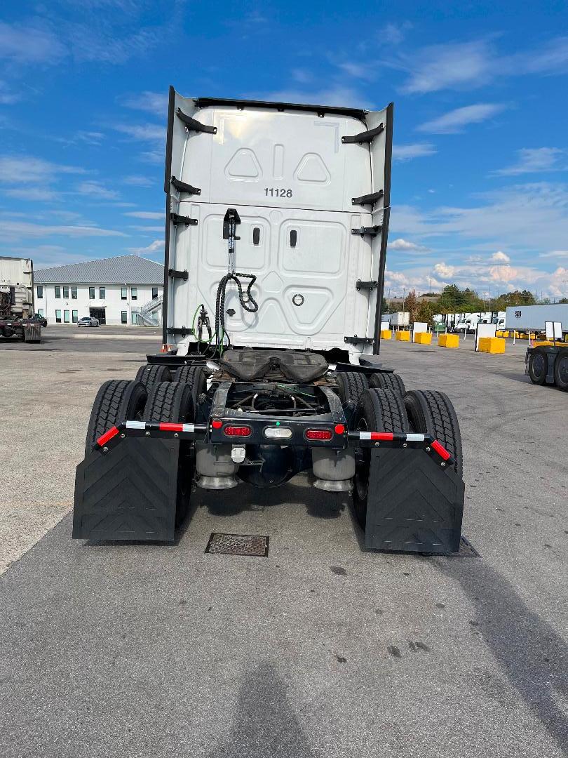 Freightliner Cascadia 126 tractor rear view showing dual rear axles, mudflaps, and fifth wheel area.