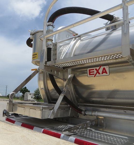 EXA aluminum vacuum tank trailer with rear view, EXA logo on tank, exposed ladders, hoses, and supporting frame.