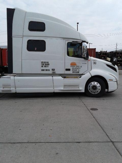 Volvo D13 truck sleeper cab side view showing door and window, with white paint and text decals on the cab