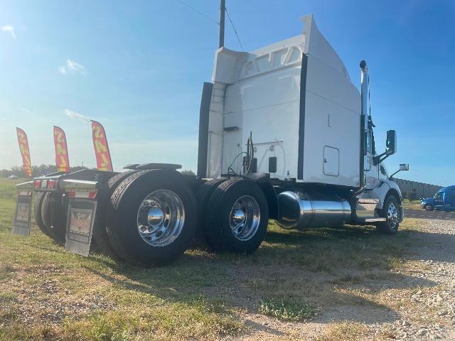 Peterbilt 579 concrete sleeper truck in a side rear angle view showing dual rear axles and chrome fuel tanks.