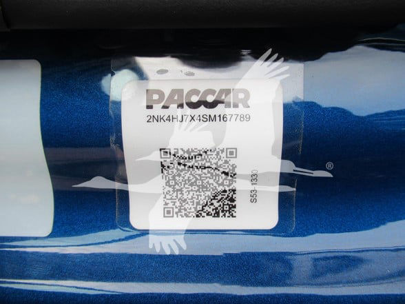 Paccar label on blue truck body showing VIN 2NK4HJ7X4SM167789 and stock number SM167789.