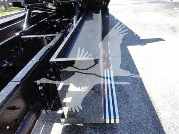 Vehicle side rail with folded flatbed step images; no legible labels visible in the photo.