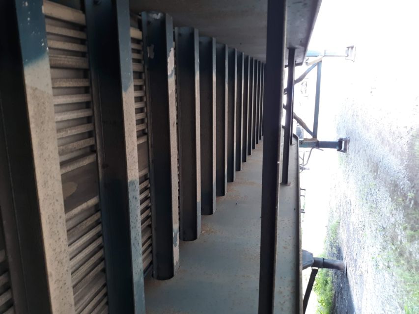 Underneath view of a trailer with a series of cross members and black framing, showing underside details.