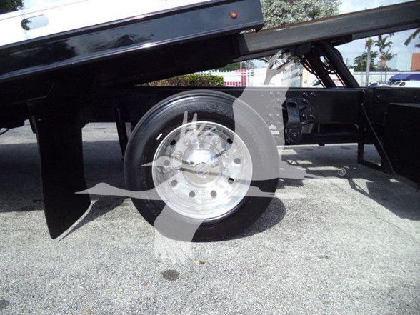 Truck chassis with single rear wheel, black undercarriage, hydraulic lift visible.