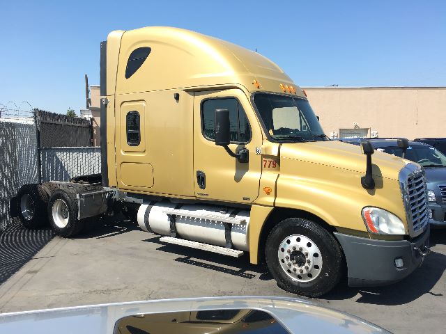 2010 Freightliner Cascadia 125 conventional sleeper truck in tan color with cab and chrome fuel tanks, chrome wheels, and attached trailer. VIN 1FUJGLDR2ASAV7036.