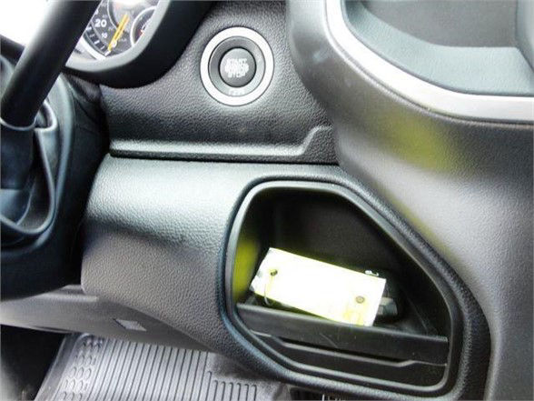 Ram 4500 dash area with push-to-start button and a small open storage pocket containing a yellow item.