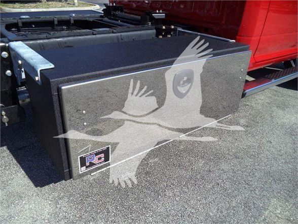 Ram 5500 truck bed toolbox mounted behind cab with RC sticker and a protective cover.