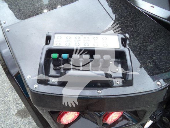 Control panel with labeled switches and a row of circular indicators on a Freightliner M2 106 heavy truck accessory console.
