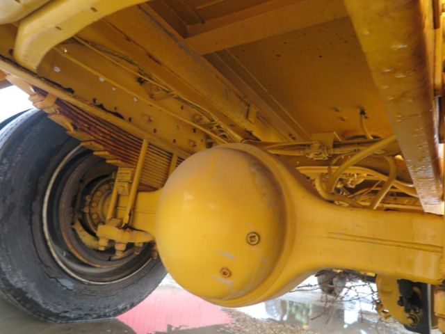 Truck rear suspension and axle housing of a 2005 International 4200 VT365 showing yellow painted components and a large housing near the wheel.