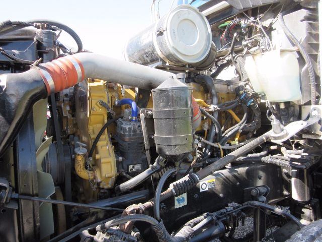 Kenworth T800 engine bay showing radiator hose, air intake canister, various hoses, wiring, and engine components.