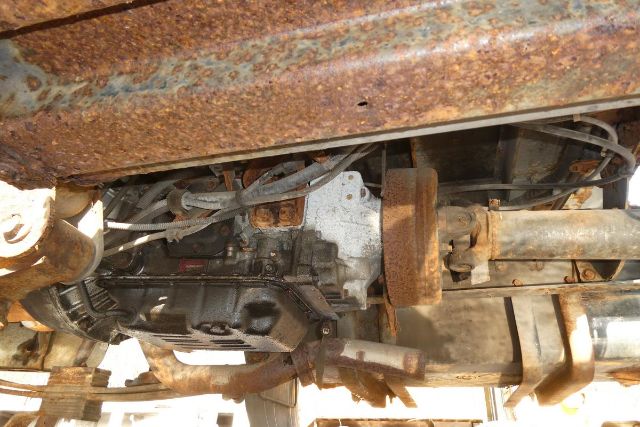Underbody view of a 2007 Hino 145 chassis showing drivetrain components including exhaust, drivetrain, and rusted frame.