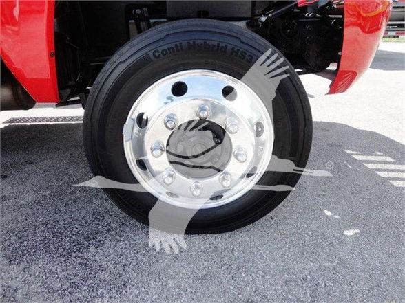 Truck wheel with Conit Hybrid HS3 tire and polished aluminum rim mounted on a red truck fender.