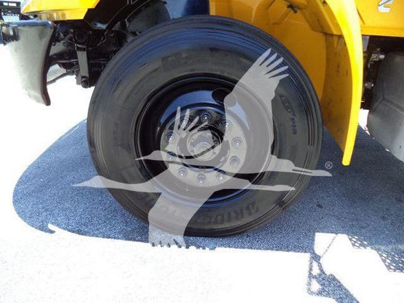 Wheel and tire close-up on a yellow International DURASTAR 4300 truck with a splash of watermark across the image.