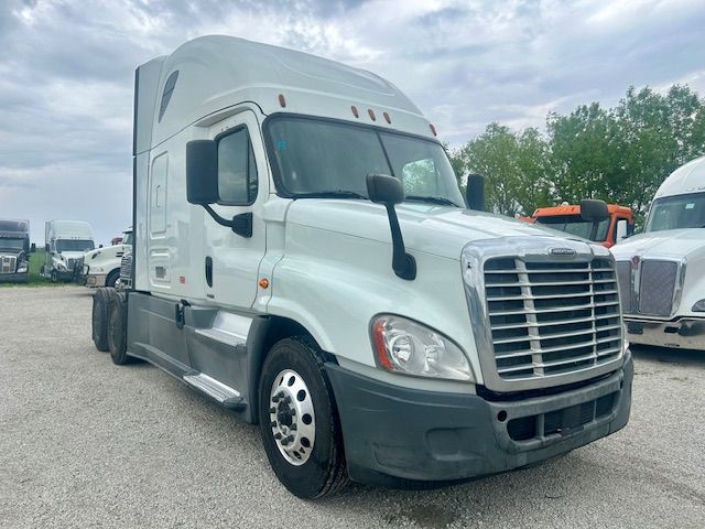 Freightliner Cascadia 125 sleeper cab truck in a parking lot, front three-quarter view showing grille, headlights, and side mirror.