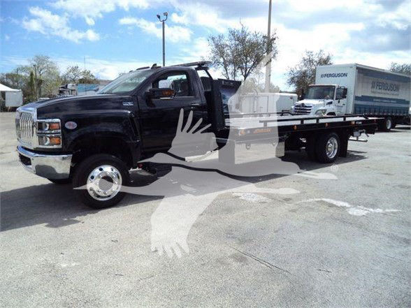Tow truck showing black International CV with flatbed and white cranes overlay