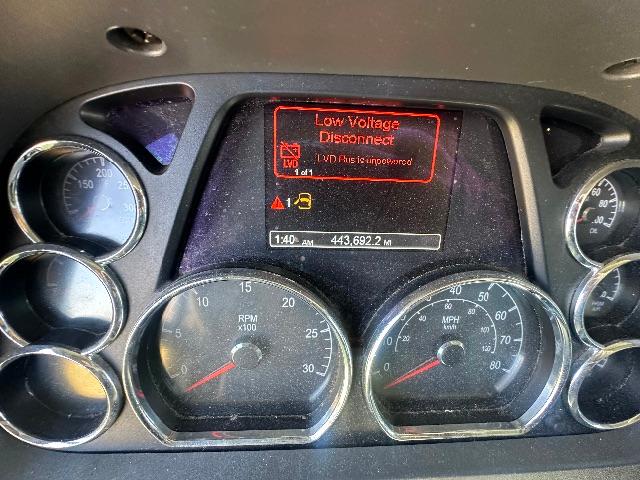 Panel view of a 2019 Peterbilt 579 gauge cluster with Low Voltage Disconnect warning on the central display.