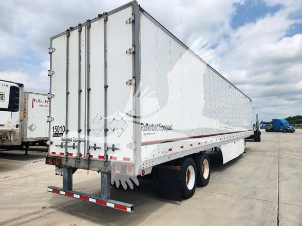 Trailer with Rollin' Earthwood branding showing rear doors, triple-axle wheels, and registration numbers; side shows white, reflective tape, and trailer structure.