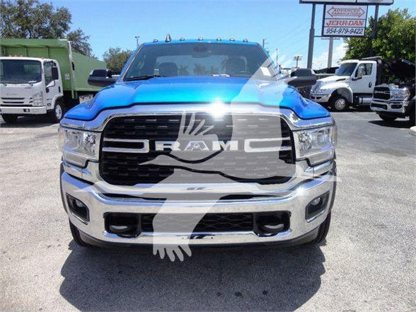 Front view of a blue 2024 Ram 5500 SLT truck showing the prominent black grille with RAM badge and chrome bumper.