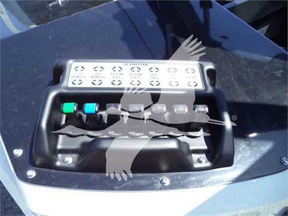 Ram 5500 tow truck hood with electrical control module and two colored knobs (green and blue) visible on top, screws at base.