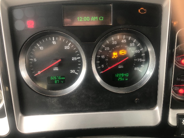 Kenworth T800 dash cluster showing tachometer and speedometer with green digital readouts and warning lights.