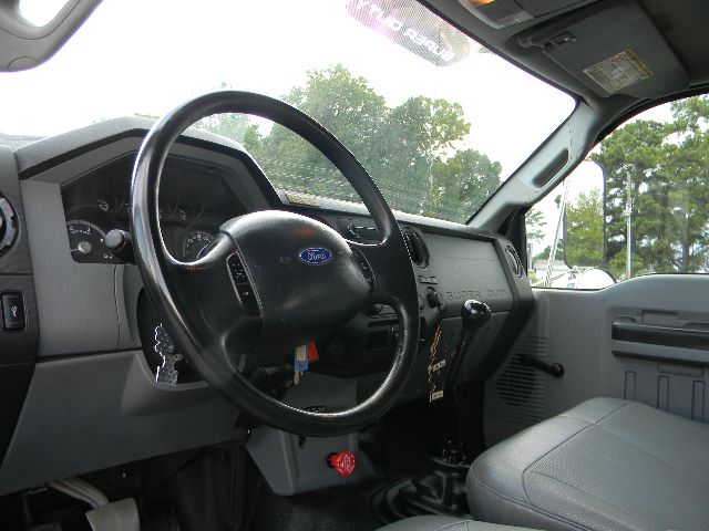 Ford F-Series cab interior showing steering wheel and dashboard with keys in ignition.