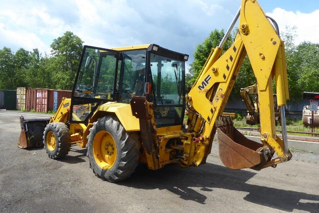 Massey Ferguson backhoe loader with yellow body and black cab showing front bucket and rear digging arm.