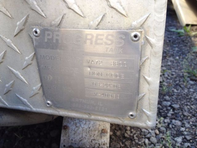Progress vacuum tank tag mounted on diamond plate surface with model and spec details faded.