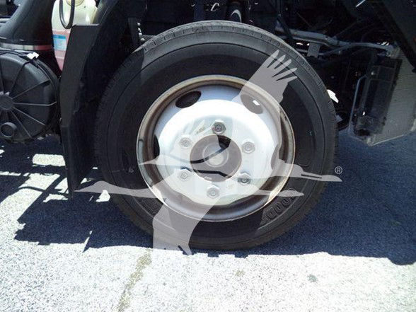 Isuzu NQR wheel and tire assembly visible in the truck chassis showing a steel rim with five lug nuts.