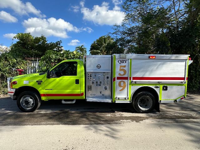 Fire department rescue truck in lime green with side compartments and 'QRV 59' markings on the rear. Side panel shows gauges and controls.